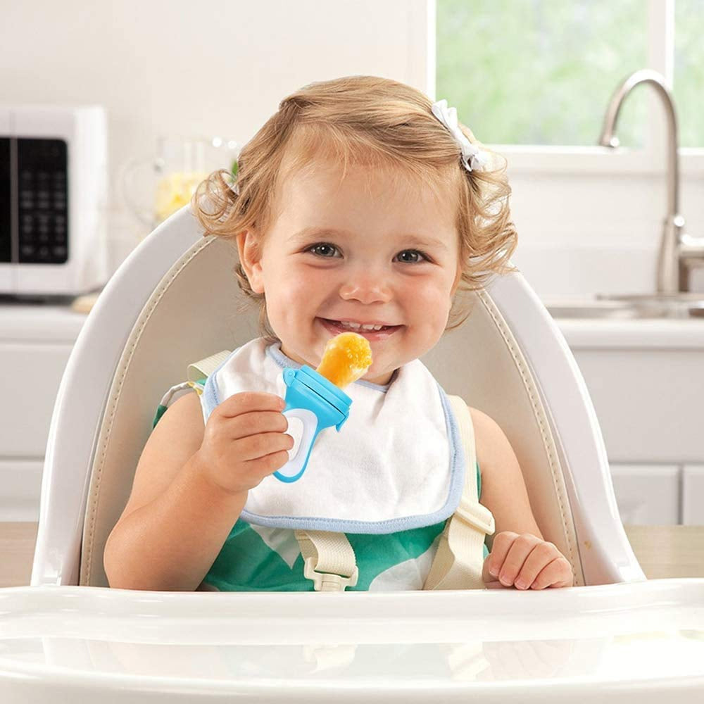 Toddler in high chair with a bib, holding a blue sippy cup, kitchen background.