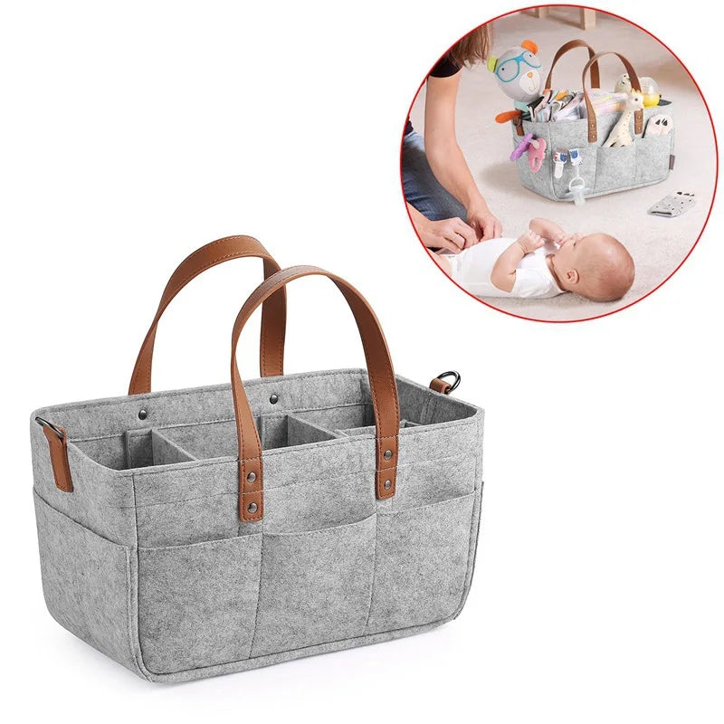 Gray Baby Felt Organizer Bag Filled With Baby Items With Photo Of Mom Changing Baby Diaper
