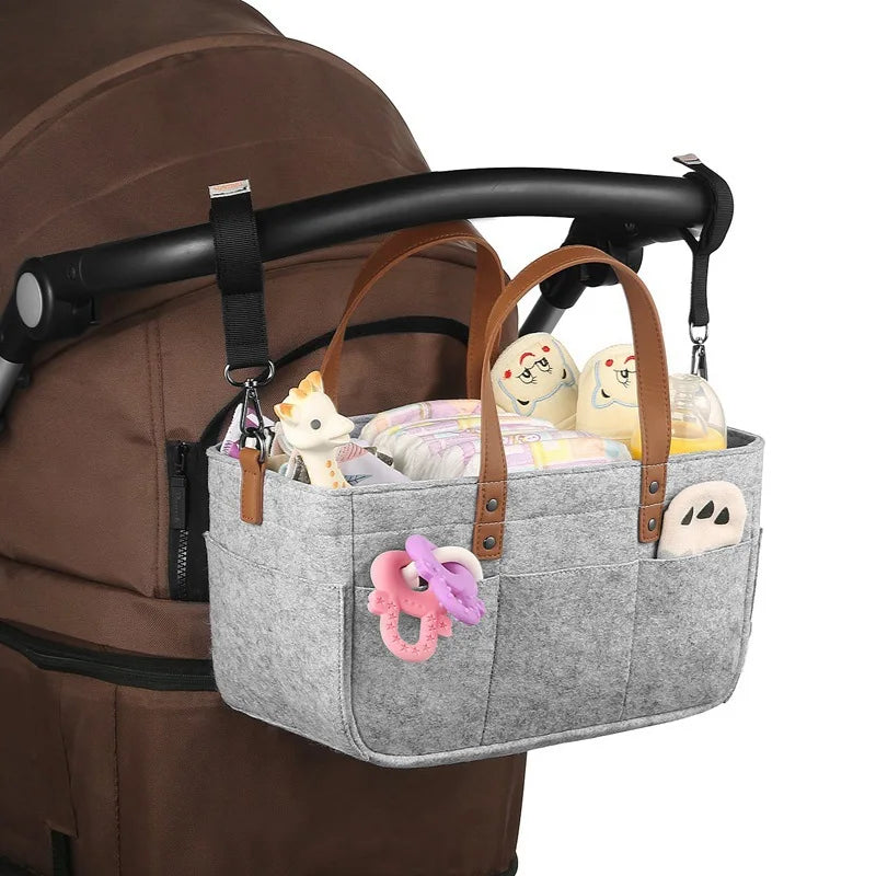 Gray Baby Felt Organizer Bag Attached In A stroller Handle In A White Background