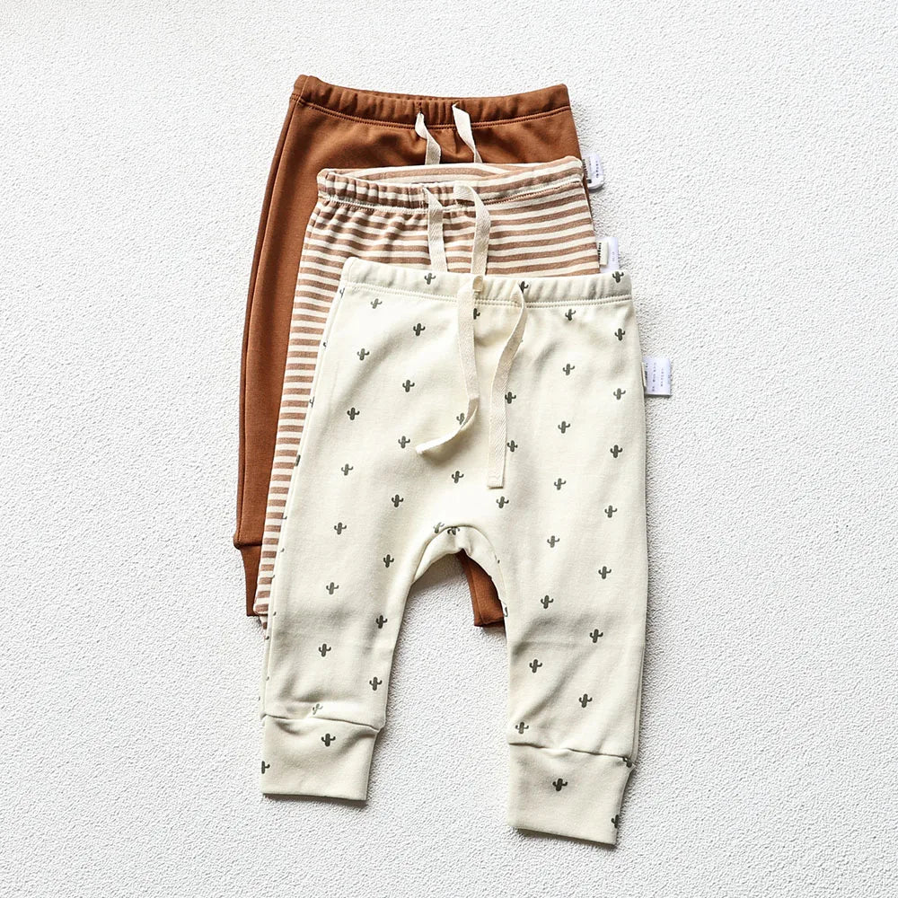 Baby Long pants in three different designs and colors in a light gray background