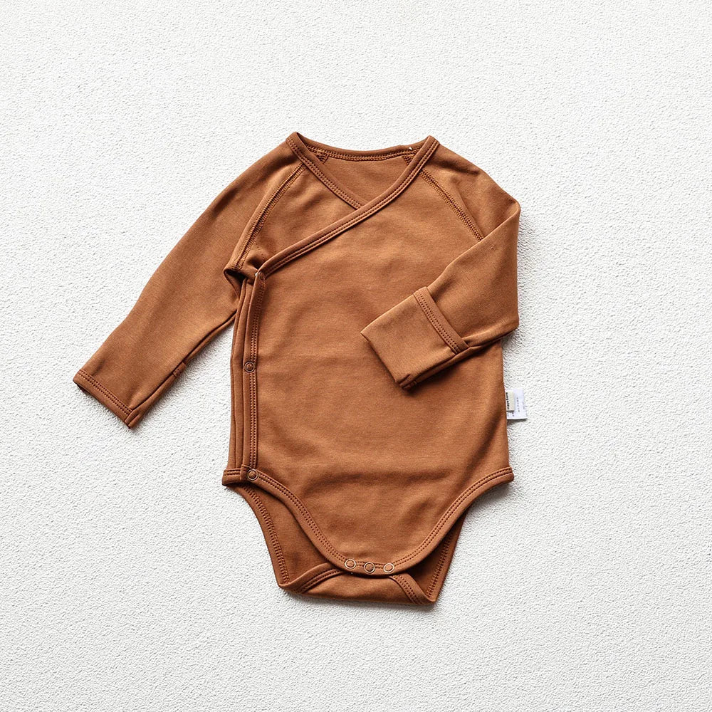 Brown baby long sleeve bodysuit in a light gray background
