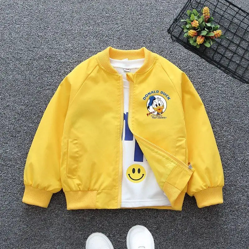 Yellow Mickey Mouse Design Printed Toddler Bomber Jacket Laid In a Gray Background With Basket Prop and White Shoes