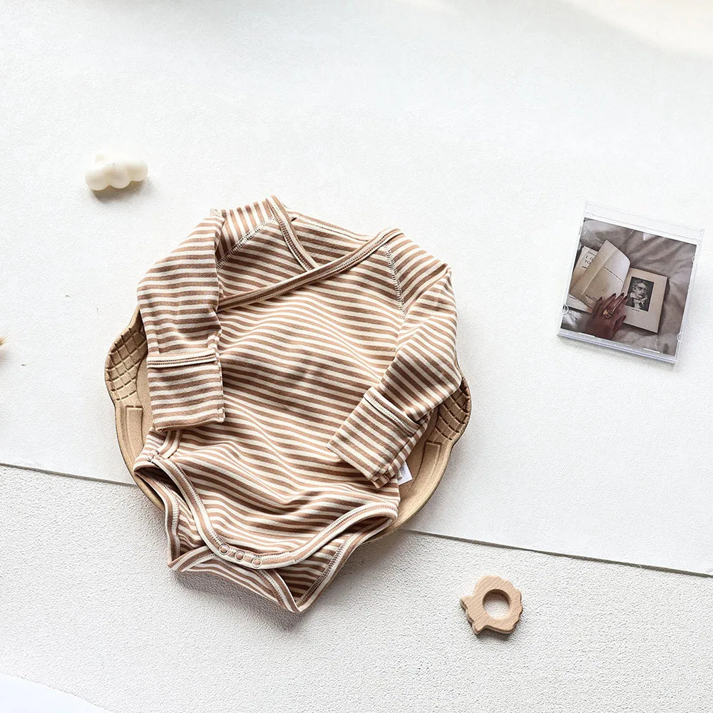 Brown and white striped sleeve bodysuit laid in a brown tray in an aesthetic light gray background