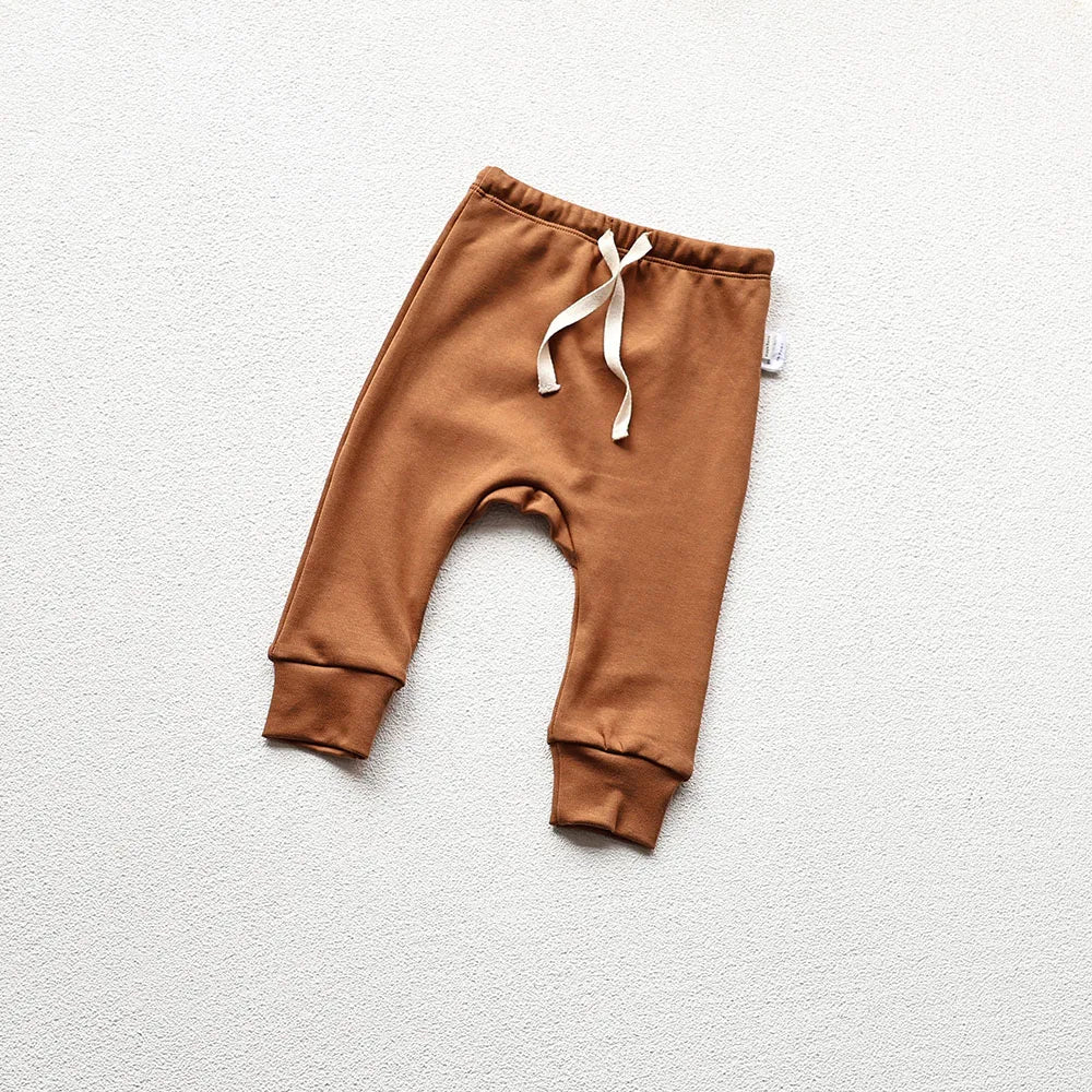 Brown baby pajama pants in a light gray background