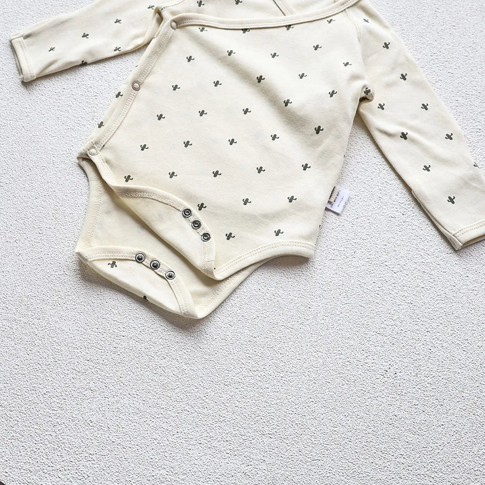 A closeup photo showing the Cactus Printed White long sleeve bodysuit's guesset