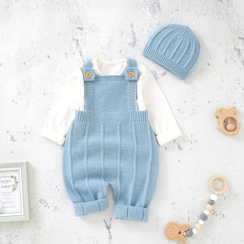 Aqua Blue Baby Knitted Romper with Hat laid in a white marble background with toys and frame props