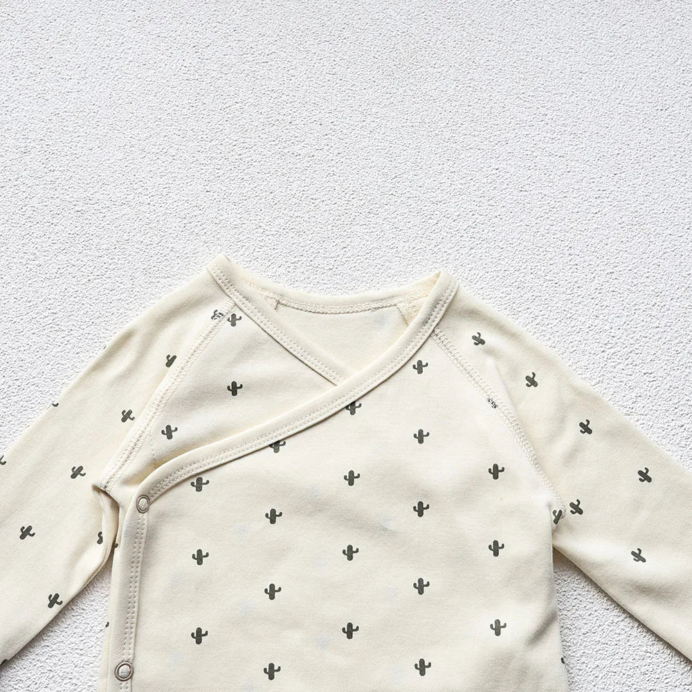 A closeup photo showing the Cactus Printed White long sleeve bodysuit's upper portion