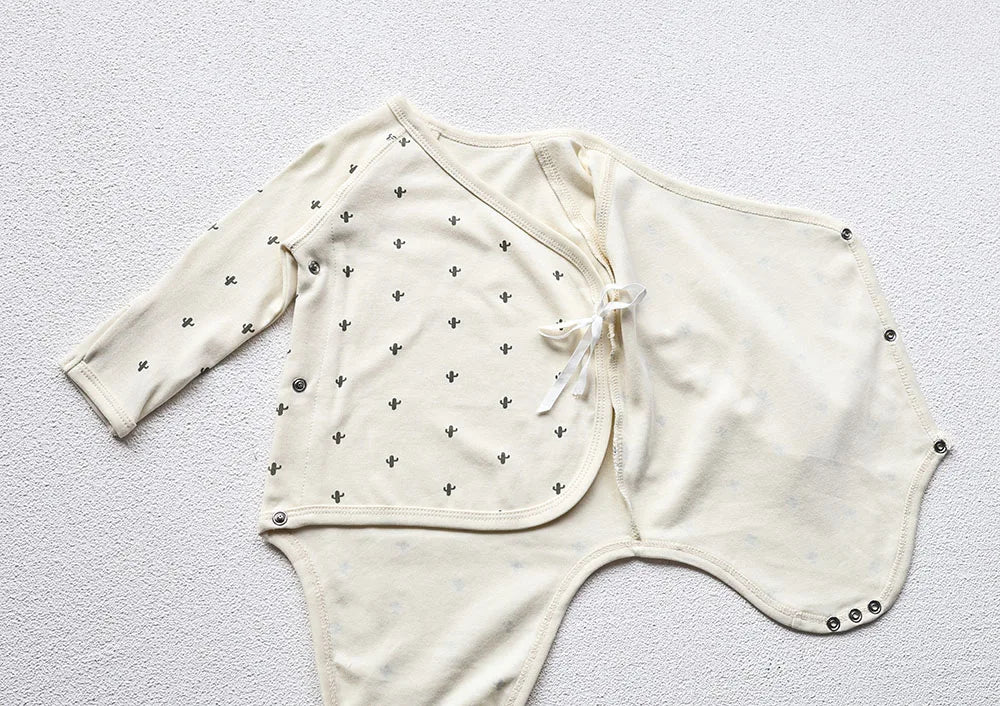 A photo of a baby's cactus Printed White long sleeve bodysuit's open front