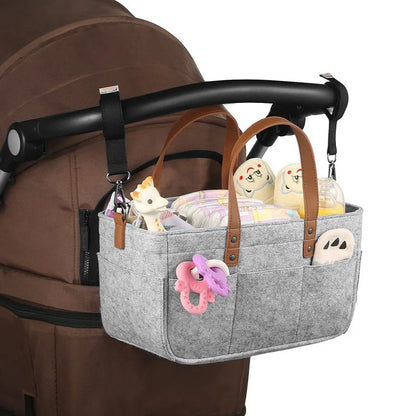 Gray Baby Felt Organizer Bag Attached In A stroller Handle In A White Background