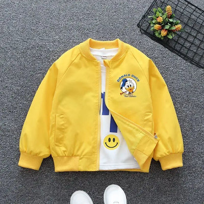 Yellow Mickey Mouse Design Printed Toddler Bomber Jacket Laid In a Gray Background With Basket Prop and White Shoes