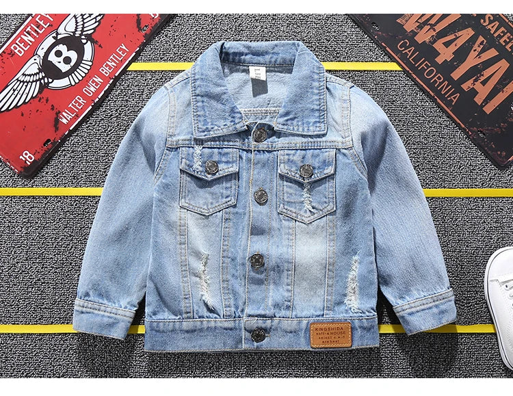 Mickey Mouse Designed Toddler Blue Denim Jacket Showcasing Front Design Laid in a Stripe Background With Car plates as props