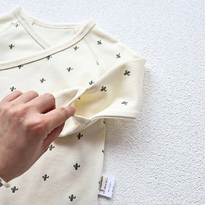  A closeup photo showing the Baby's cactus Printed White long sleeve bodysuit's handcuff's pocket