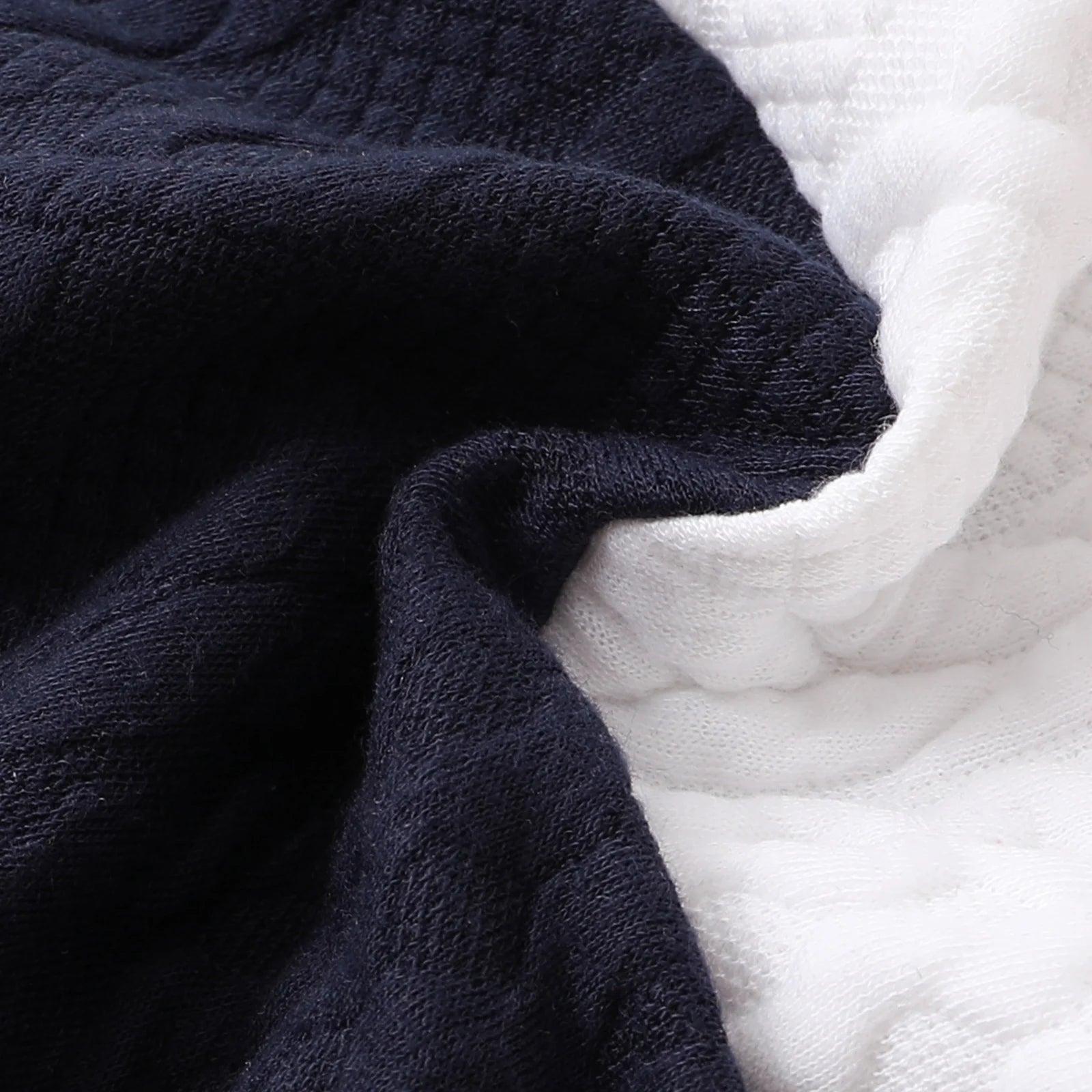 A Close Up Picture Of Red, White, and Navy Blue Colorblock Baby Jumpsuit Romper's Fabric