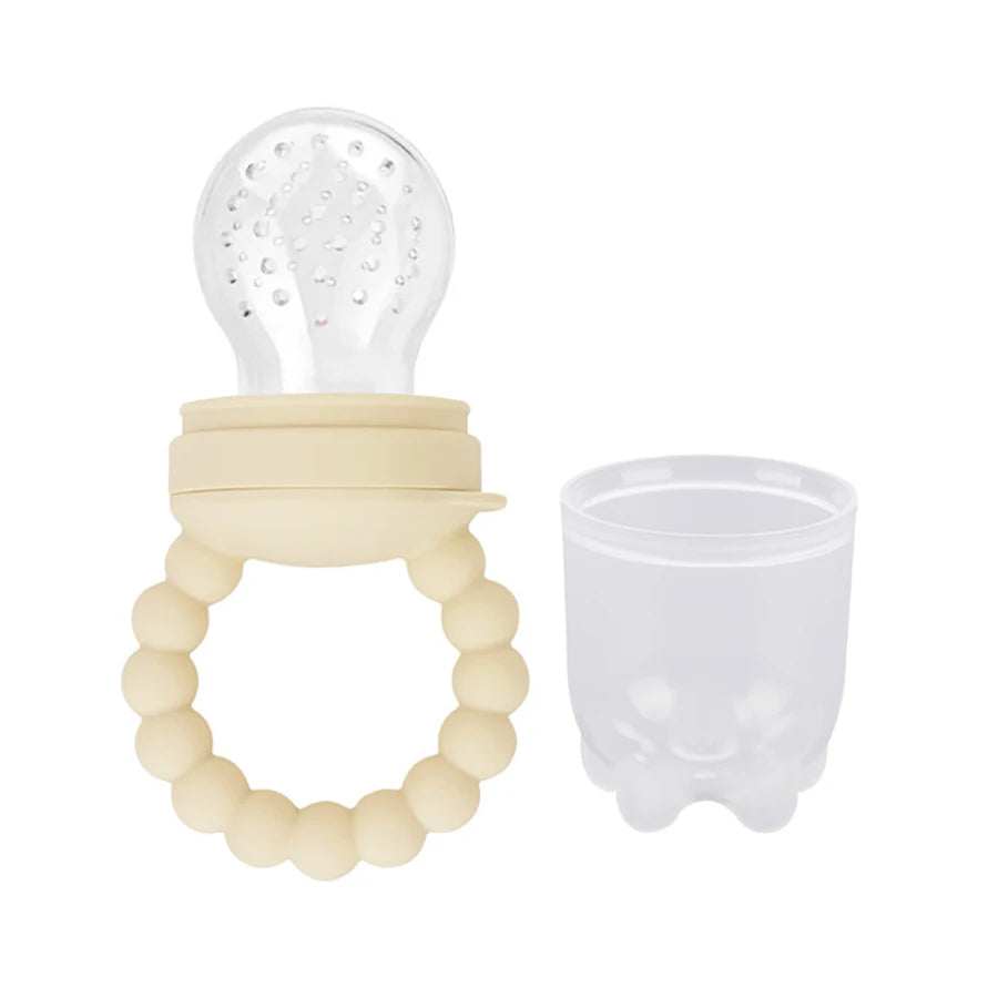 Baby teething toy with silicone bristle top and beaded handle next to its transparent cup.