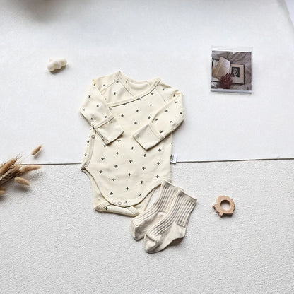 Cactus Printed White long sleeve baby bodysuit with white socks in an aesthetic light gray background