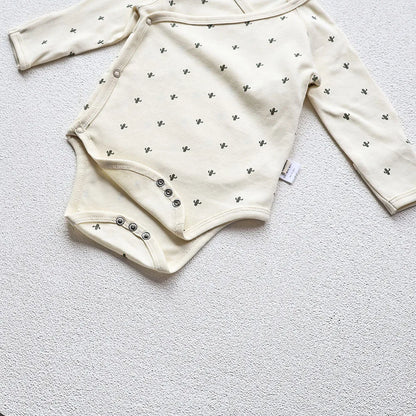 A closeup photo showing the Cactus Printed White long sleeve bodysuit's guesset