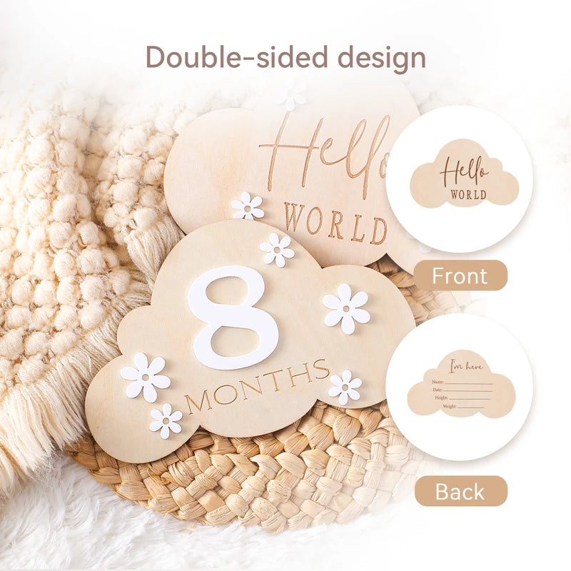 A cloud shaped wooden milestone card displaying Hello World alongside another card displaying 2 months, in a neutral aesthetic background, highlighting double sided design