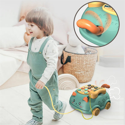 A child in overalls pulling a toy phone with a cat design.