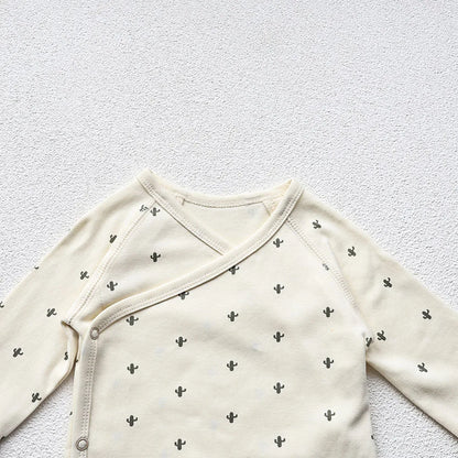 A closeup photo showing the Cactus Printed White long sleeve bodysuit's upper portion