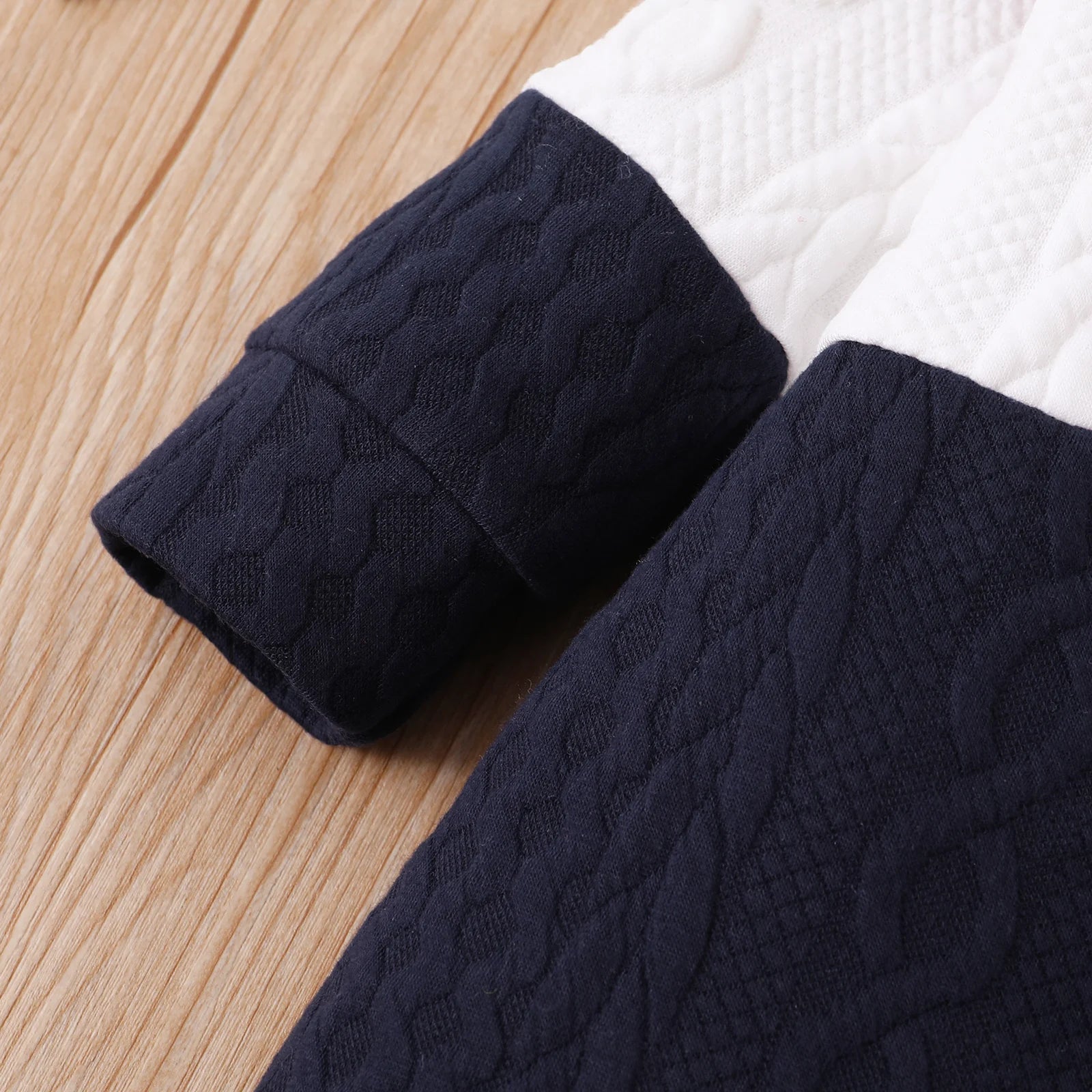 A Close Up Picture Of Red, White, and Navy Blue Colorblock Baby Jumpsuit Romper's Sleeve